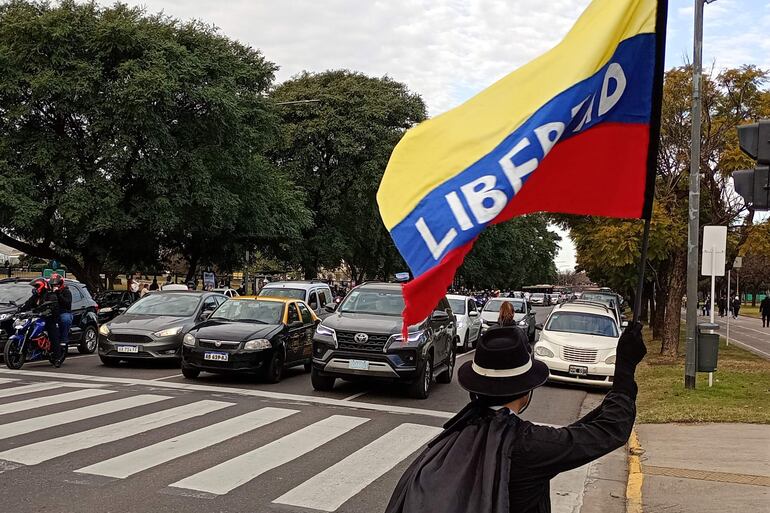 Un hombre ondea una bandera frente a una caravana de ciudadanos venezolanos que va a la embajada de Venezuela, con motivo de las elecciones presidenciales en Venezuela, en Buenos Aires (Argentina).