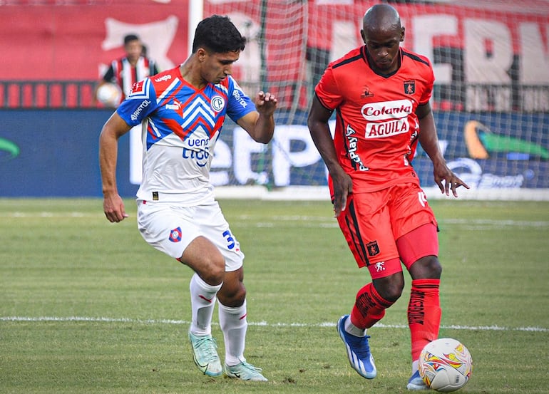 Tobías Portillo,  volante ofensivo de Cerro Porteño, mete presión al lateral izquierdo del América de Cali Marcos Mina.