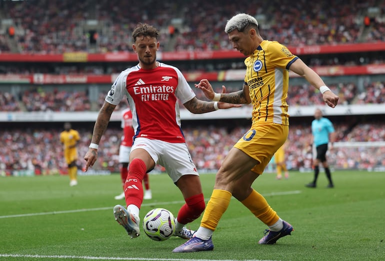 El paraguayo Julio Enciso (d), jugador del Brighton, pelea por el balón en el partido frente al Arsenal por la tercera fecha de la Premier League en el Emirates Stadium, en Londres, Inglaterra. 