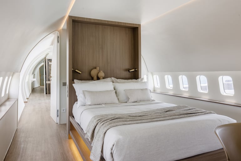 Dormitorio flanqueado por las ventanillas de la aeronave. Foto: Private Jet Villa/Geometrium Studio.
