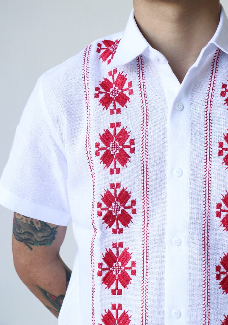 Bordados con hilos rojos en el pecho de la guayabera.