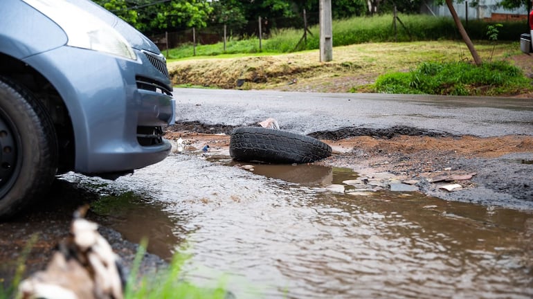 Una rueda en un pozo lleno de agua sobre la avenida Avelino Martínez, en San Lorenzo.