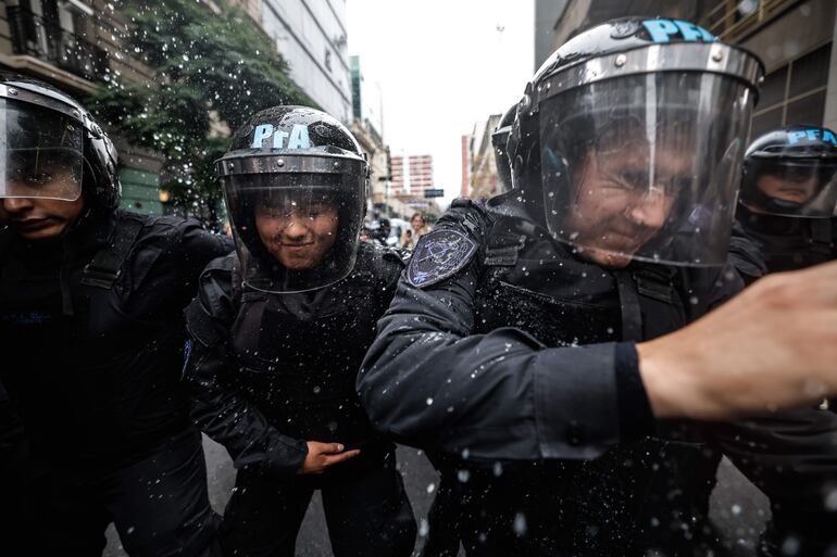 Policías se enfrentan a personas que protestan a las afueras del senado durante un debate, en Buenos Aires (Argentina).  