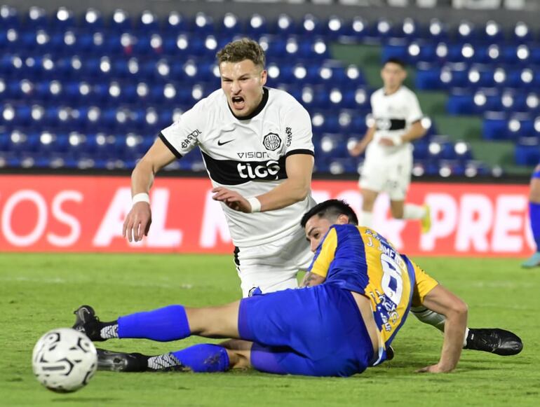 El argentino Facundo Bruera, futbolista de Olimpia, cae al suelo durante una disputa de balón en el partido contra Sportivo Luqueño por la octava fecha del torneo Clausura 2023 del fútbol paraguayo en el estadio Defensores del Chaco, en Asunción.