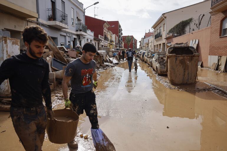 Vecinos de La Torre limpian las calles y sus viviendas, este viernes. Miles de personas se han desplazado desde Valencia a La Torre para ayudar a los afectados por las inundaciones causadas por la DANA, este viernes. La búsqueda de desaparecidos, la identificación de víctimas mortales, las tareas de limpieza y la reparación de infraestructuras continúan tres días después de las inundaciones que han asolado la provincia de Valencia, en una jornada en la que el Gobierno envía a 500 militares más, que se sumarán a las 1.200 efectivos de la Unidad Militar de Emergencias (UME), para actuar en Utiel, Requena, Riba-roja, Torrent, Paiporta y Algemesí.