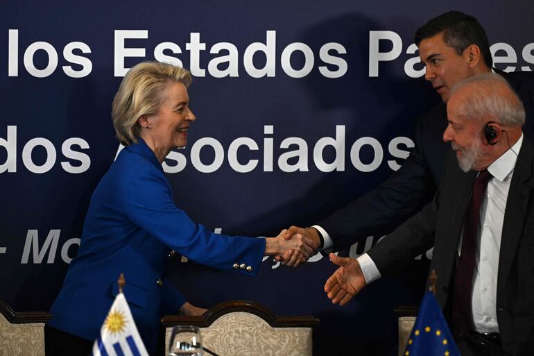 La presidenta de la Comisión Europea, Úrsula von der Leyen saluda al presidente paraguayo, Santiago Peña (al fondo) y al mandatario de Brasil, Lula da Silva (d), durante la Cumbre del Mercosur, en Uruguay.