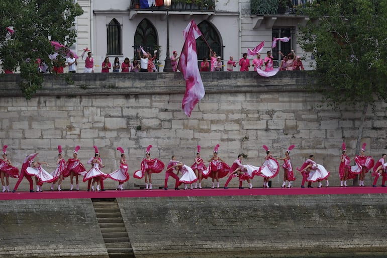 Varios artistas bailan el cancán a orillas del río Sena al paso de la selecciones olímpicas durante la ceremonia de inauguración de los Juegos Olímpicos de París 2024, este viernes en la capital francesa. 