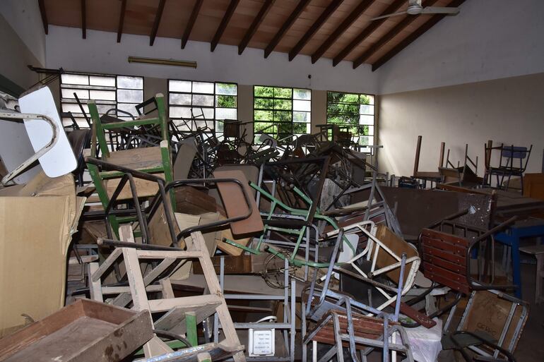 Salón de clases lleno de sillas que ya no pueden ser utilizadas por los alumnos por estar en mal estado.