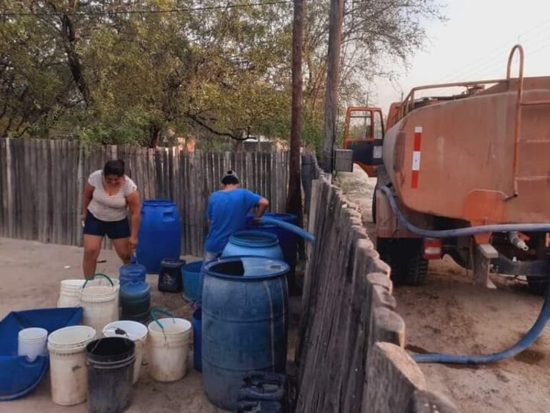 Cualquier recipiente sirve para bajar el agua que trae el camión cisterna.