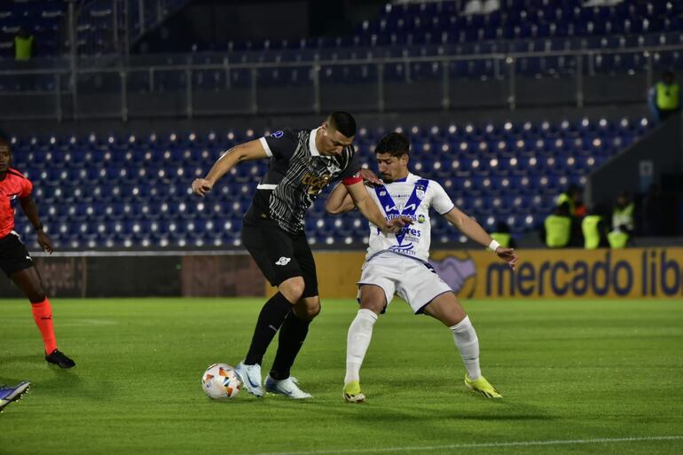 Oscar Cardozo trata de dominar el balón ante la marca de Aldo Maíz