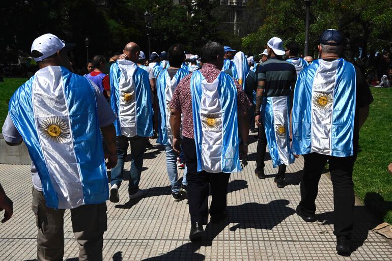 Miembros de sindicatos que portan banderas nacionales de Argentina protestan contra el presidente Javier Milei.