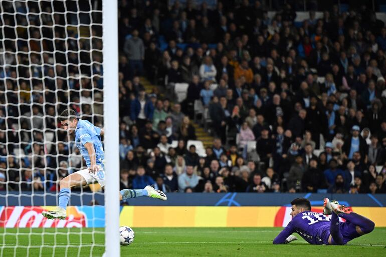 El delantero argentino del Manchester City #19 Julián Álvarez anota el primer gol de su equipo pasando al portero israelí del Estrella Roja #18 Omri Glazer durante el partido de fútbol del Grupo G de la Liga de Campeones de la UEFA entre el Manchester City y el FC Crvena Zvezda (Estrella Roja de Belgrado) en el estadio Etihad de Manchester.