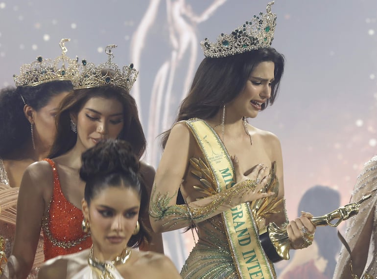 Rachel Gupta, de la India (con corona y banda) mira su trofeo luego de ganar el título de  Miss Grand International 2024.