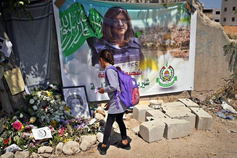 YENÍN, 27/05/2022.- Una niña deja flores junto a un retrato de la periodista de Al Yazira Shireen Abu Akleh, en Yenín, Cisjordania. EFE/ Sara Gómez Armas
