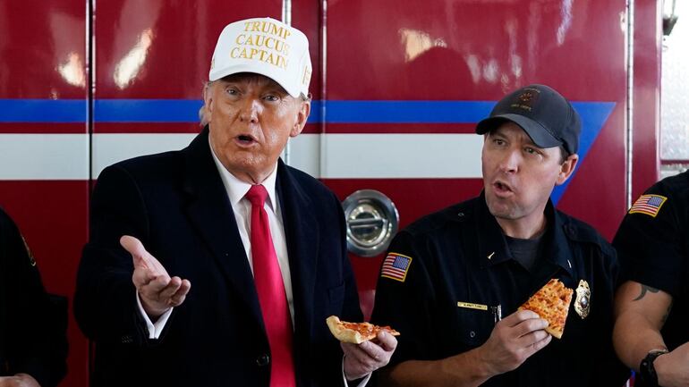 "En la jornada de la venganza de Trump en Iowa, que compró pizzas a sus militantes, sólo en la calle hacía frío". (Foto: AP)