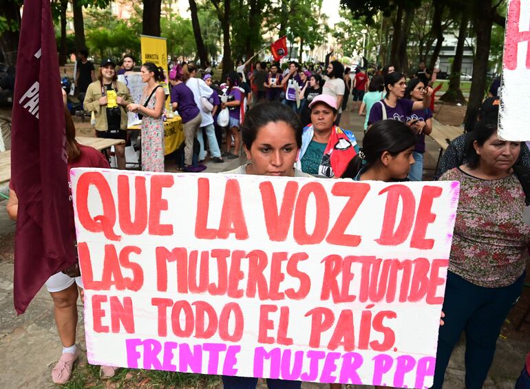 Marcha de mujeres desde la plaza de Uruguaya, exhibiendo varias pancartas.  