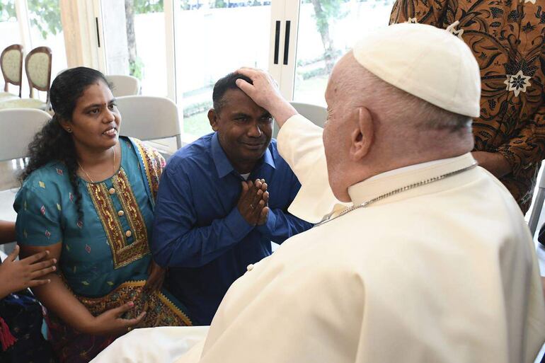 El papa Francisco saluda, a su llegada a la nunciatura de Yakarta tras un vuelo de 13 horas, a un grupo de refugiados acogidos por el Servicio Jesuita a Refugiados, niños huérfanos criados por monjas dominicas y ancianos, y migrantes y personas sin hogar acompañados por la Comunidad de San Egidio. 