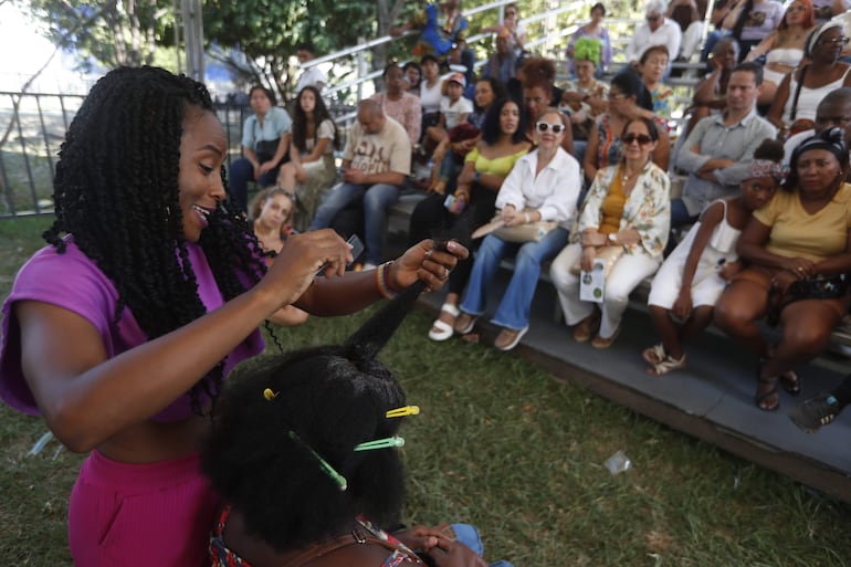 Una mujer es peinada durante el Festival Petronio Álvarez el 18 de agosto de 2023 en Cali (Colombia).
