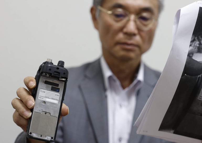 El director del fabricante japonés de walkie-talkie Icom Inc., Yoshiki Enomoto, muestra su dispositivo de radio modelo IC-V82 durante una entrevista en la oficina central de la compañía en Osaka, Japón occidental, el 19 de septiembre de 2024.