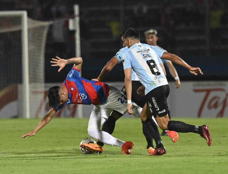 Claudio Aquino, jugador de Cerro Porteño, ante la marca de Miguel Paniagua y Marcelo Acosta, de Guaireña.