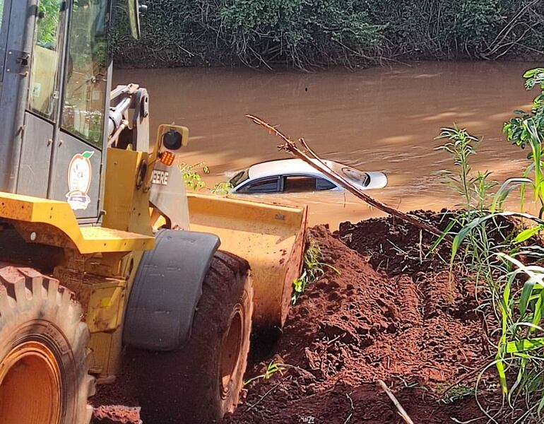 Momento en que el tractor estira el automóvil para sacarlo del río.