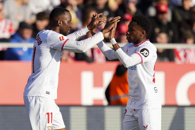 El extremo belga del Sevilla FC Dodi Lukebakio (i) celebra tras anotar un gol ante el Girona, el segundo del equipo andaluz, durante el partido de LaLiga EA Sports en el Estadio de Montilivi de Girona este sábado.