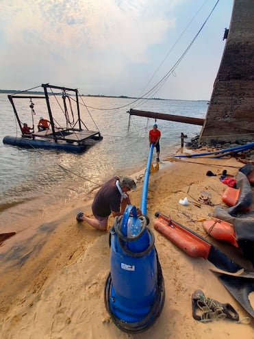 Funcionarios de la Essap instalan una bomba para captar agua del río Paraguay en Pilar.