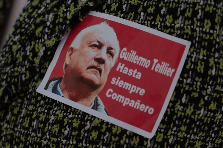 Una militante porta hoy un retrato del presidente del Partido Comunista (PC) de Chile, Guillermo Teillier, durante su velorio en la antigua sede del Congreso Nacional en Santiago (Chile). 