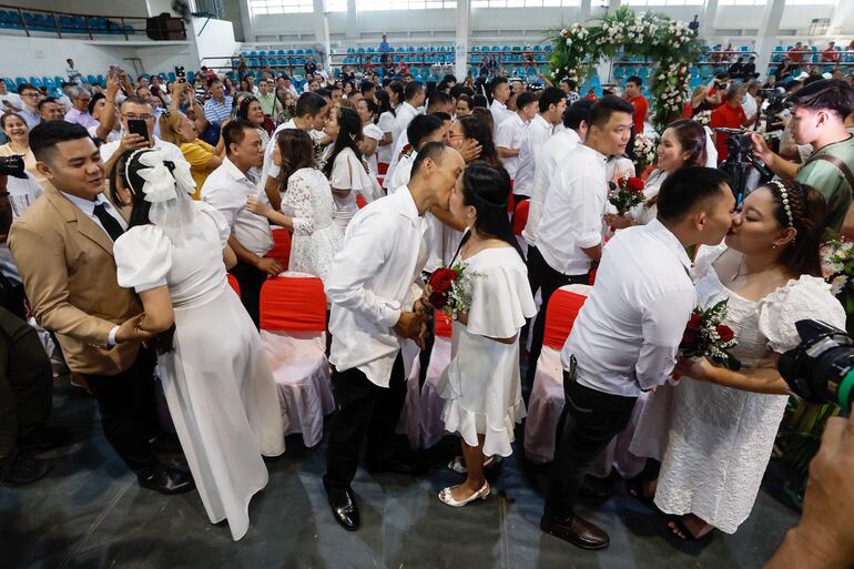 San Juan (Filipinas), las parejas se besan durante una ceremonia de boda civil masiva que conmemora el día de San Valentín en un gimnasio en la ciudad de San Juan, Metro Manila, Filipinas. 