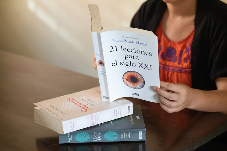 Una mujer lee el libro 21 lecciones para el siglo XXI, de Yuval Noah Harari.