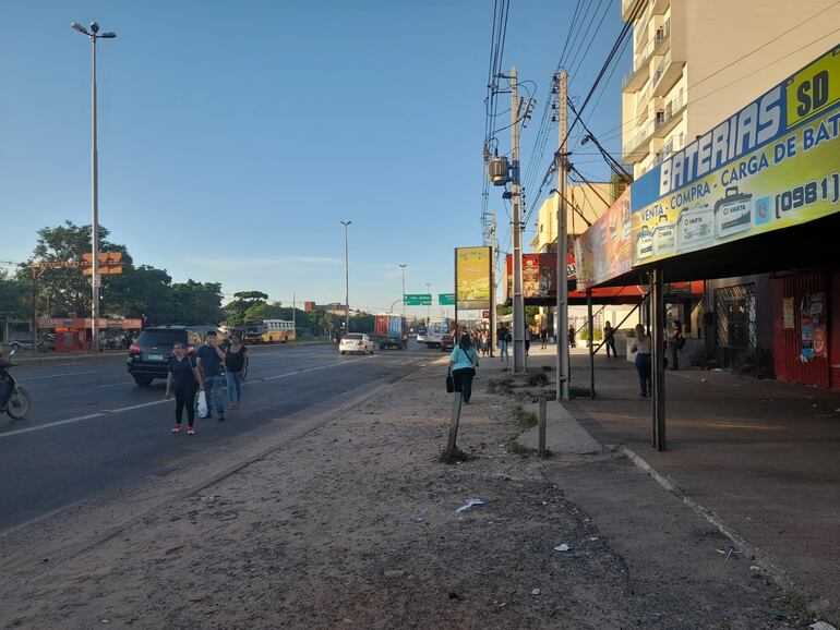 Pasajeros esperando al costado de la ruta PY03. Hay poca cantidad de colectivos, por lo que deben aguardar por varios  minutos.