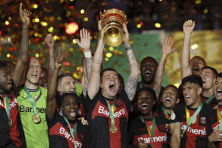 Los jugadores del Bayer Leverkusen celebran con el trofeo de la Copa Alemania la consagración de campeón en el estadio Olímpico, en Berlín. 