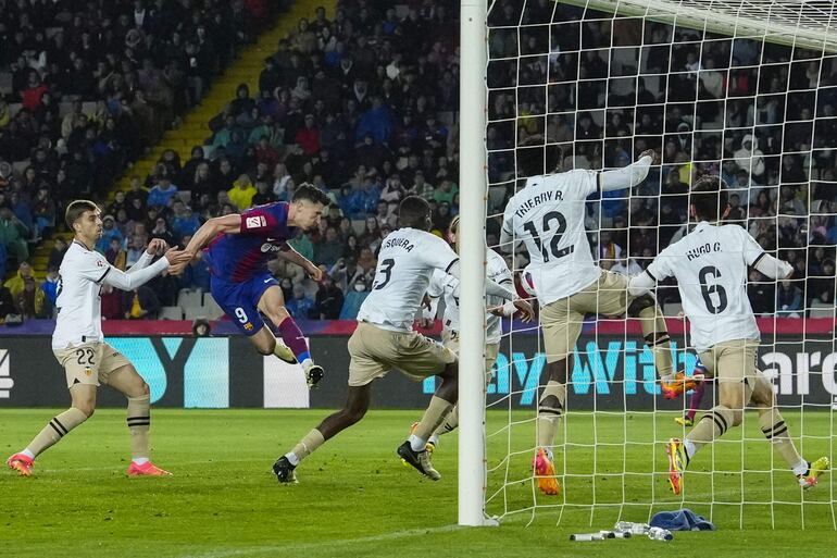 BARCELONA, 29/04/2024.- El delantero polaco del FC Barcelona Robert Lewandowski (2i) remata de cabeza para marcar su segundo gol durante el partido de la jornada 33 de Liga en Primera División que FC Barcelona y Valencia CF disputan este lunes en el Estadio Olímpico Lluis Companys. EFE/Enric Fontcuberta.
