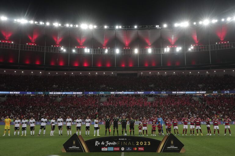 Los jugadores de Flamengo (d) y de Olimpia (i) forman en un partido de los octavos de final de la Copa Libertadores en el estadio Maracaná en Río de Janeiro, Brasil.
