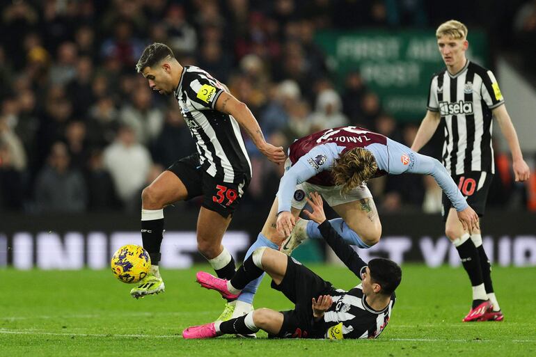 El paraguayo Miguel Almirón (en el suelo, futbolista del Newcastle, pelea por el balón en un partido frente al Aston Villa por la jornada 22 de la Premier League en el estadio Villa Park, Birmingham, Inglaterra.