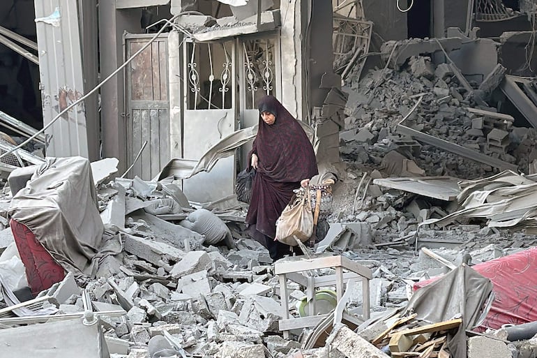 Una mujer camina entre escombros de un edificio destruido por bombardeos israelíes el lunes en Beit Lahia, en el norte de la Franja de Gaza.