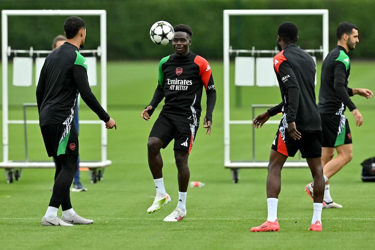 Arsenal's English midfielder #07 Bukayo Saka (C) focuses on the ball during a training session at the Arsenal Training centre in Shenley in Hertfordshire on September 30, 2024 on the eve of their UEFA Champions League 1st round day 2 football match against Paris Saint-Germain. (Photo by Glyn KIRK / AFP)