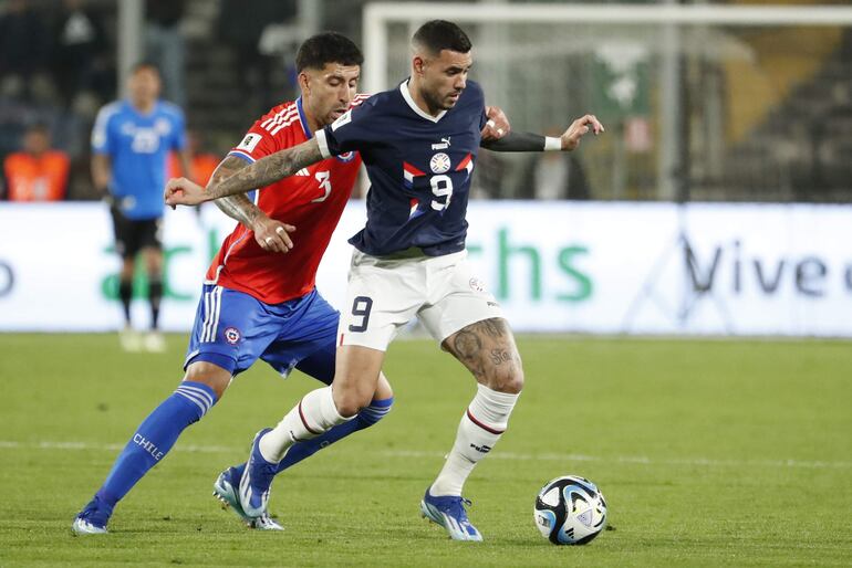 Antonio Sanabria (d), delantero de la selección paraguaya, domina el baló frente a Guillermo Maripán, futbolista de Chile, en un partido de las Eliminatorias Sudamericanas 2026 en el estadio Monumental, en Santiago, Chile.