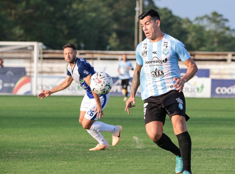 José Verdún (Guaireña) observa el balón ante la marca de Julio González (Ameliano).