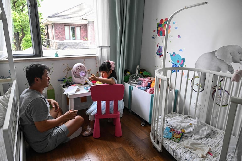 Chen Hualiang interactúa con su hija pequeña en Shanghái.