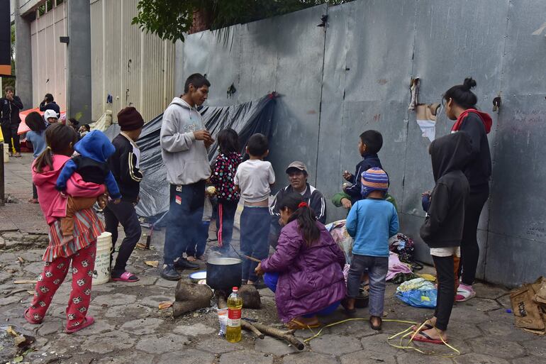 Familias de indígenas del distrito de Caaguazú preparan el almuerzo en la vereda, frente al Indi.