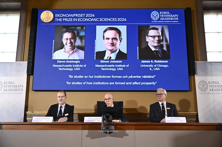 El secretario permanente de la Academia de Ciencias, Hans Ellegren (centro), Jakob Svensson (izquierda) y Jan Teorell, de la asamblea Nobel del Riksbank sueco, anuncian en memoria el premio del Riksbank sueco en ciencias económicas del Alfred Nobel 2024, que corresponde a Daron Acemoglu, Simon Johnson y James A Robinson, durante una rueda de prensa en la Real Academia Sueca de Ciencias en Estocolmo, Suecia.