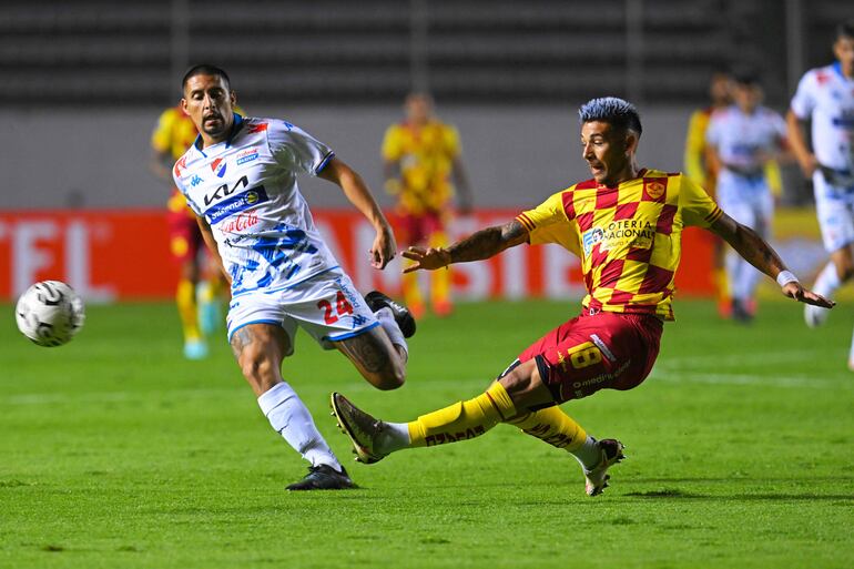 El mediocampista de El Nacional Jhon Santacruz (L) y el defensor de Aucas Juan Cruz González (R) luchan por el balón en el partido de fútbol de primera fase de la Copa Libertadores entre Aucas y El Nacional en el estadio Gonzalo Pozo Ripalda de Quito el 8 de febrero de 2024.