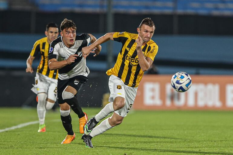 Santiago Silva (i) de Danubio disputa hoy el balón con Walter Clar de Guaraní, durante un partido por el Grupo B de la Copa Sudamericana en el Estadio Centenario en Montevideo (Uruguay).