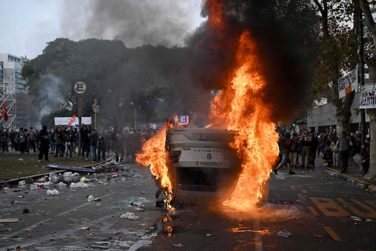 Un automóvil de la estación de radio Cadena 3 de Argentina fue incendiado durante una protesta frente al Congreso Nacional en Buenos Aires ayer 12 de junio.