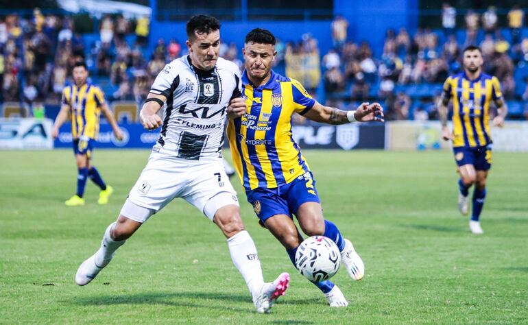 El  atacante de Tacuary, Néstor Camacho intenta imponer el físico ante la marca del lateral Rodi Ferreira.