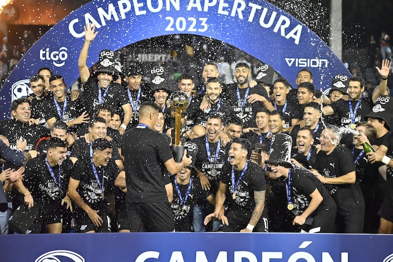 Los jugadores de Libertad celebran con el trofeo de campeón del torneo Apertura 2023 del fútbol paraguayo.