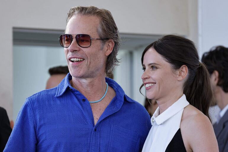 El actor británico Felicity Jones y la actriz Guy Pearce posando juntos a llegar al Festival de Cine de Venecia. (EFE/EPA/FABIO FRUSTACI)
