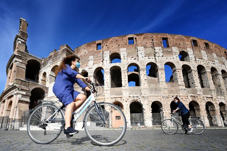 Una mujer circula en bicicleta frente al Coliseo romano. La artrosis en la Edad Media estaba causada por un exceso de trabajo físico, mientras que hoy en día es el sedentarismo lo que la provoca, según un estudio presentado este viernes que analiza restos óseos de los siglos XI y XII encontrados durante las excavaciones efectuadas en el Parque Arqueológico del Coliseo.