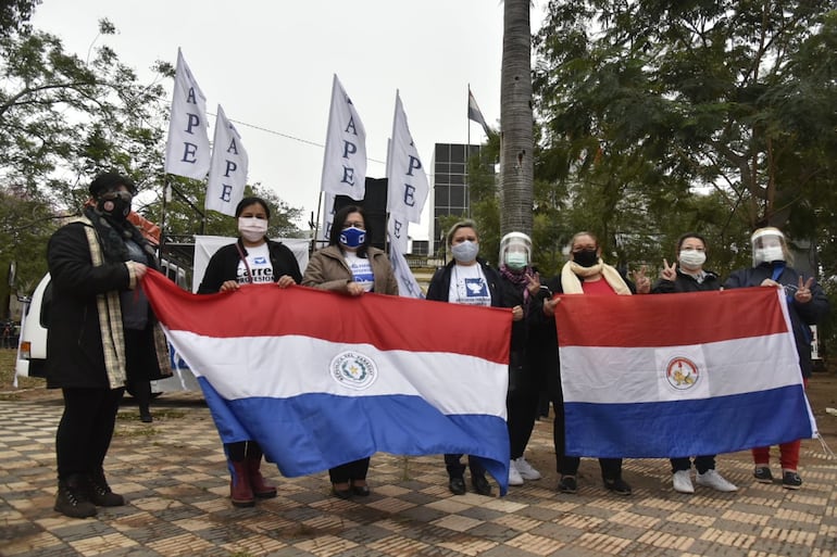 Integrantes de la Asociación Paraguaya de Enfermería (APE) se manifiestan frente al Congreso Nacional, con banderas paraguayas.